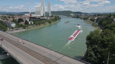 4K-Drohnenvideo-Von-Schleppern,-Die-Lastkähne-Auf-Dem-Rhein-In-Der-Nähe-Der-Wettsteinbrücke-In-Basel,-Schweiz-Ziehen