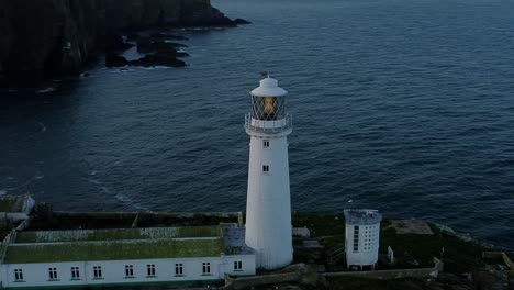 Luftaufnahme-Des-Leuchtturms-South-Stack,-Der-Das-Maritime-Küstenleuchtfeuer-Umkreist-Und-Die-Meereslandschaft-Zur-Goldenen-Stunde