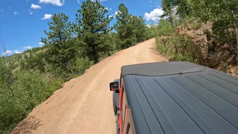 POV---View-of-vehicle-rooftop-while-driving-on-a-scenic-byway-in-Rocky-Mountains