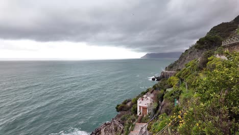 Overlooking-the-sea-horizon-with-the-rugged-coastline-near-the-village-of-Riomaggiore,-Italy,-capturing-the-wild-beauty-and-dramatic-landscape-of-this-coastal-region