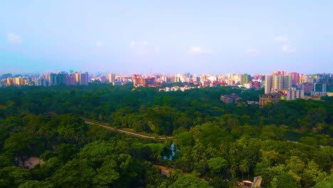 Vista-Aérea-Del-Bullicioso-Paisaje-Urbano-De-Dhaka,-Bangladesh,-Con-La-Serena-Vegetación-Del-Parque-Ramna-Creando-Un-Sorprendente-Contraste.