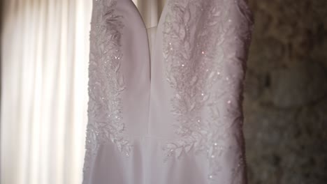 Close-up-of-a-wedding-dress-with-delicate-lace-detailing,-softly-lit-by-natural-light