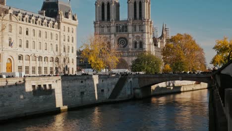 Vertical-pan-of-Notre-Dame-Cathedral-after-the-fire-seen-from-across-the-Seine-river-on-a-beautiful-autumn-day