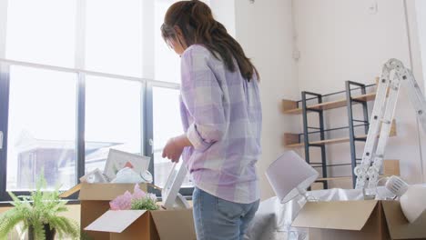 Women-with-Adhesive-Tape-Packing-Boxes-at-Home.moving,-people-and-real-estate-concept--women-with-adhesive-tape-packing-boxes-at-home