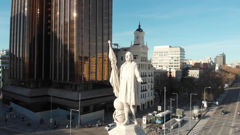 Plaza-De-Colón-De-Madrid,-Monumento-A-Cristóbal-Colón,-4k-A-24-Fps-Con-Un-Primer-Plano-Del-Monumento-En-Una-Tarde-De-Cielo-Azul