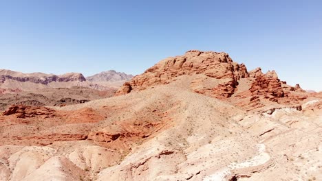 Vista-Aérea-De-Formaciones-De-Arenisca-De-Roca-Roja-Y-Colinas-En-El-Desierto-De-Nevada