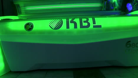 Tanning-sunbed-with-lid-open-green-LED-lights-lighting-up-machine