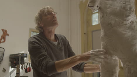 Artist-checking-and-working-on-a-plaster-sculpture