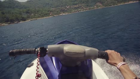 Vista-En-Primera-Persona-De-Una-Moto-Acuática-Saltando-A-Gran-Velocidad-Sobre-El-Agua-En-Un-Mar-Azul.