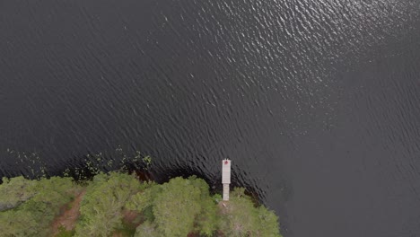 Imágenes-Aéreas-De-Un-Puente-En-El-Bosque-Al-Borde-Del-Lago-En-Skoludden-Mirando-Hacia-Abajo-Al-Mirador-Desde-Donde-Se-Ve-La-Isla-Que-Flota-Cada-Verano