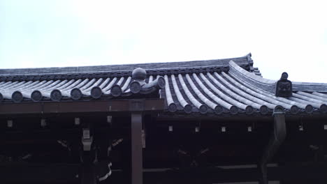 Walking-by-a-rooftop-made-by-Japanese-traditional-rooftop-panels-in-Kyoto,-Japan-with-soft-lighting-4k