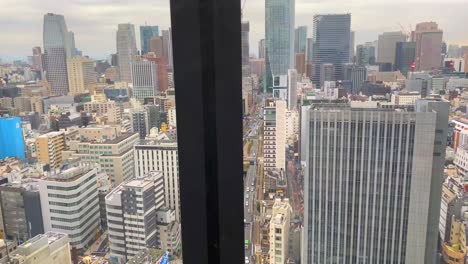 Elevator-view-going-down-in-Tokyo-Japan-in-a-tall-skyscraper-building,-urban-city-view