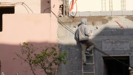 4k-static-shot-of-single-man-doing-construction-work-during-Marrakech-golden-hour