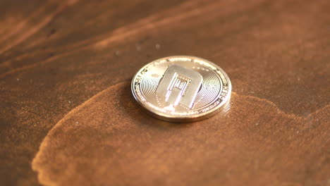 Dashcoin-cryptocurrency-close-up-orbit-shot-on-wood-grain