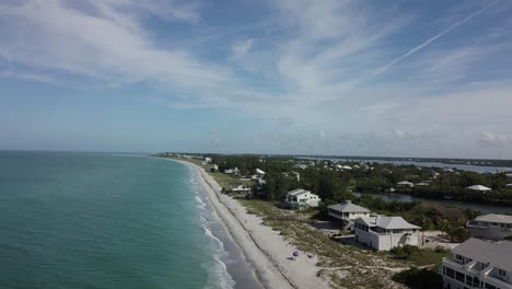 High-birds-eye-point-of-view,-drone-flying-straight-along-beach-with-small-waves-crashing-on-shoreline