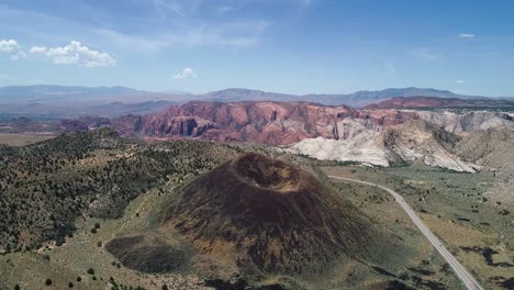 Volando-Alto-Sobre-Un-Antiguo-Volcán-Cubierto-De-Vegetación-A-Lo-Largo-De-Una-Carretera-En-Utah