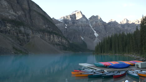 Lago-Morrena-Con-Canoas-De-Colores-Al-Frente-Y-Agua-Turquesa,-Montaña-Y-árboles-Al-Fondo.