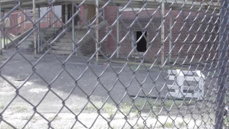 Forefront-of-fence-with-old-dilapidated-building-in-background