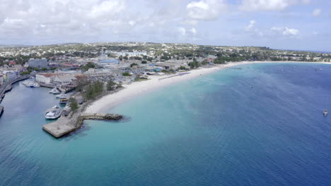 Increíble-Toma-Aérea-Con-Drones-De-Bridgetown,-Barbados,-Que-Muestra-El-Comienzo-De-Todas-Las-Playas-Principales,-El-Lugar-Donde-Comienzan-Las-Excursiones-De-Pesca-Del-Pez-Espada-Y-El-Estacionamiento-Trasero-Para-Embarcaciones-Privadas.