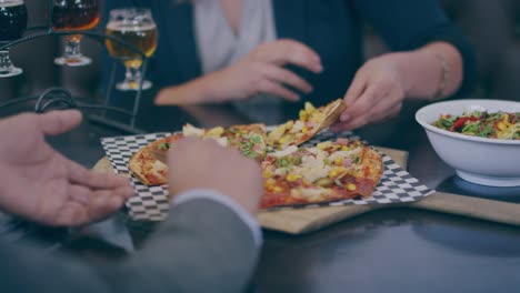 Eating-pizza-and-salad-with-with-friends-at-the-table-with-books-and-beer