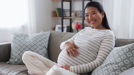 Feliz-Mujer-Asiática-Embarazada-Con-Computadora-Portátil-En-Casa.-Concepto-De-Embarazo,-Descanso,-Personas-Y-Expectativas-Feliz-Sonriente-Mujer-Asiática-Embarazada-Con-Computadora-Portátil-Sentada-En-Un-Sofá-En-Casa