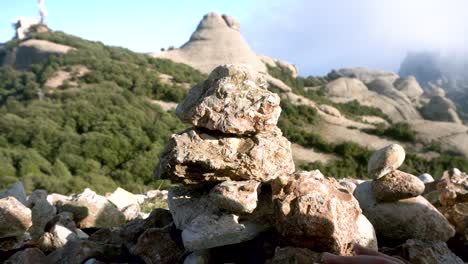 Un-Par-De-Manos-Apilando-Rocas-Junto-A-Un-Valle-De-Piedra