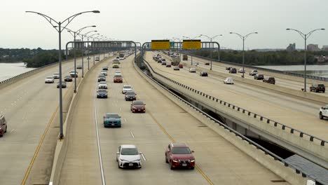 Vehicles-driving-over-the-Woodrow-Wilson-Bridge-and-Potomac-River-between-Maryland-and-Virginia-on-a-cloudy-day-traveling-towards-camera-into-Maryland