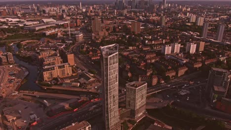 Vista-Aérea-Del-Dron-Desde-El-Atardecer-En-Londres-Hacia-El-Edificio-Blanco,-Tráfico-En-Canary-Wharf