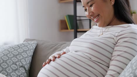 Feliz-Mujer-Asiática-Embarazada-Con-Computadora-Portátil-En-Casa.-Concepto-De-Embarazo,-Descanso,-Personas-Y-Expectativas-Feliz-Sonriente-Mujer-Asiática-Embarazada-Con-Computadora-Portátil-Sentada-En-Un-Sofá-En-Casa