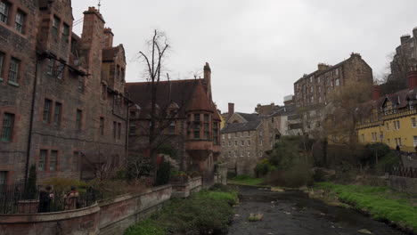 Schwenkaufnahme-Von-Dean-Village-Mit-Rustikalen-Alten-Historischen-Gebäuden-Und-Einem-Fluss-An-Einem-Schönen-Sonnigen-Tag-In-Edinburgh,-Schottland