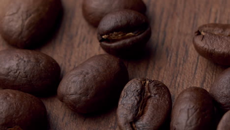 Roasted-coffee-beans-fall-on-a-wooden-surface