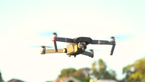 Drone-takes-off-from-grass-and-hovers-in-air,-tracking-medium-shot