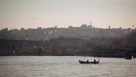 Traditional-Sunset-view-of-Golden-Horn-in-Istanbul-while-Boat-and-Seagulls-Passing-by-Slowly