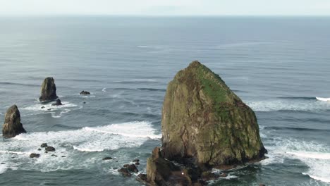 Atemberaubende-Luftaufnahmen-Des-Berühmten-Wahrzeichens-Der-Küste-Oregons,-Haystack-Rock-Am-Cannon-Beach