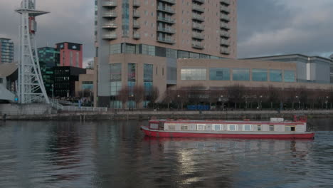 Pan-shot-of-a-pleasure-boat-in-front-of-the-lowry-center-at-Salford-keys