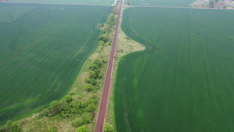 Straight-red-train-track-running-along-with-the-farm-fields-in-Hungary