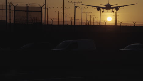 Flugzeug-Landet-über-Dem-Verkehr-Bei-Sonnenuntergang