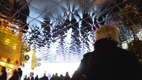 Interior-view-of-amusement-park-arcade-of-people-and-bright-shiny-reflective-mirror-ceiling,-slow-motion