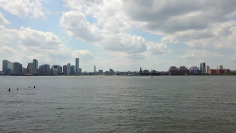 Drone-Deslizándose-Hacia-La-Derecha-Con-Un-Barco-En-El-Río-Hudson:-Ciudad-De-Nueva-York,-Fondo-De-Jersey-City