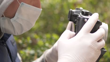 Close-up-of-man-wearing-mask-and-gloves-shoots-stock-video-on-coronavirus-pandemic-crisis