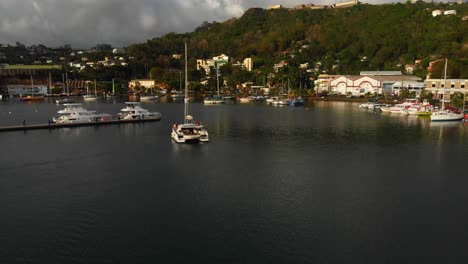 Aerial-footage-of-a-Catamaran-sail-boat-sailing-into-to-Harbour-after-touring-the-island-of-Grenada