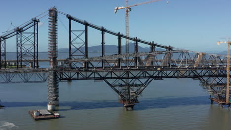 Hercilio-Luz-Bridge-under-restoration-works-with-huge-cranes,-aerial-shot