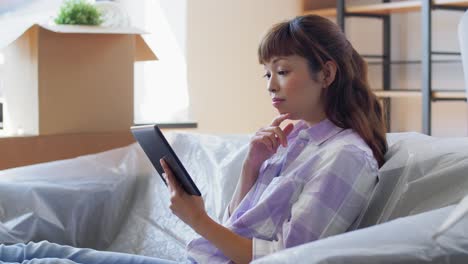 Mujeres-Con-Una-Tableta-PC-Mudándose-A-Una-Nueva-Casa.-Mudanza,-Personas-Y-Concepto-Inmobiliario.-Mujeres-Felices-Y-Sonrientes-Con-Una-Tableta-PC-Y-Cajas-Hablando-Y-Planificando-En-Una-Nueva-Casa.