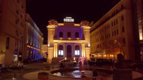 Teatro-Odeón-Iluminado-Por-La-Noche-Con-Una-Fuente-En-La-Avenida-Victoria,-Bucarest,-Rumania