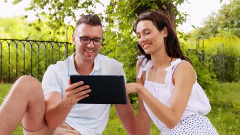 Pareja-Feliz-Con-Una-Tableta-En-Un-Parque-De-Verano.-Concepto-De-Ocio-Y-Personas.-Pareja-Feliz-Con-Una-Tableta-En-Un-Parque-De-Verano.