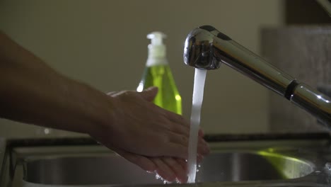 Prevention-coronavirus-Man-washes-his-hands-with-running-water-and-green-soap-in-sink