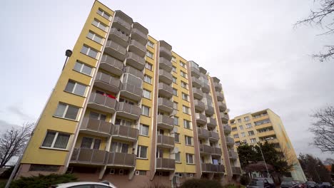 Avanzando-Hacia-Una-Casa-De-Paneles-En-Una-Urbanización-Con-Cielo-Nublado-Arriba