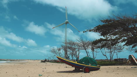 A-boat-and-wind-turbine-in-Brazil,-the-first-wind-farm-on-the-northeast