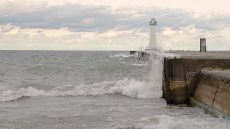 Extreme-Waves-Crashing-On-The-Lakeshore-Of-Lake-Ontario-In-Western-New-York-With-The-Famous-Sodus-Point-Lighthouse-During-Lake-Flooding---Wide-Shot