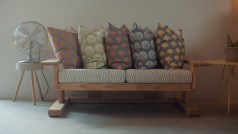 Push-in-on-custom-printed-pillow-covers-on-hand-made-bench-in-studio